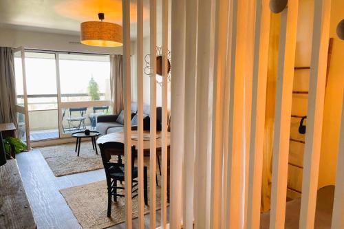 une salle à manger avec une table et un salon dans l'établissement Aux Flots Bleus avec balcon et vue sur mer, à Trouville-sur-Mer