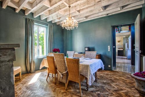 une salle à manger avec une table, des chaises et un lustre dans l'établissement Villa 1880 - Centre Ville - Jardin Botanique, à Cabourg