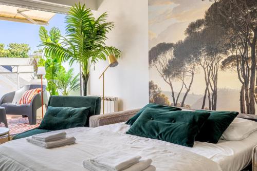 a bedroom with a bed with green pillows at Le Raffiné - Studio avec balcon, proche de l'océan in La Baule