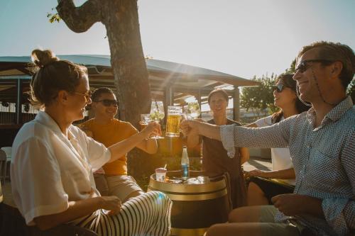 a group of people sitting around a table drinking beer at Camping Village Lago Maggiore in Dormelletto