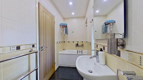 a bathroom with a sink and a toilet and a tub at Botany Bay Beach House - Stunning Sea Views in Kingsgate