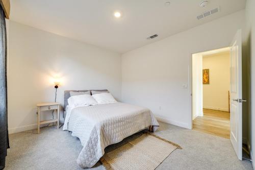 a white bedroom with a bed and a table at 4 Mi to San Joaquin River Manteca Home with Patio! in Manteca
