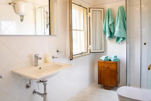 a bathroom with a sink and a toilet and a window at Agriturismo La Genziana in Alghero