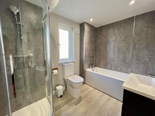 ein Badezimmer mit Toilette, Dusche und Waschbecken in der Unterkunft Stylish 3-Bed Seaview Retreat with Balcony - Steps from the Beach - Westward Ho! in Westward Ho