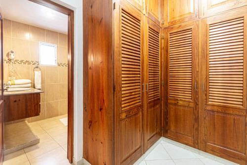 a bathroom with a wooden shower stall and a sink at Alicia Beach, Hispaniola Sol, great location - no car needed! in Sosúa