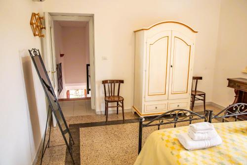 a room with a bed and a dresser and chairs at Agriturismo La Genziana in Alghero