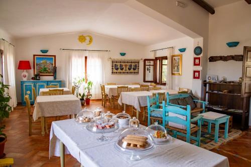 a dining room with tables and blue chairs at Agriturismo La Genziana in Alghero