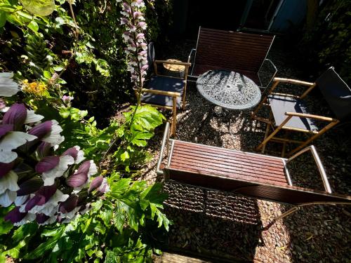 a garden with two chairs and a table and flowers at Modern Seaside Townhouse feat Sauna near Brighton in Shoreham-by-Sea
