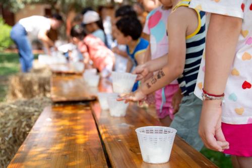 a group of people standing around a table with cups on it at Agriturismo La Genziana in Alghero