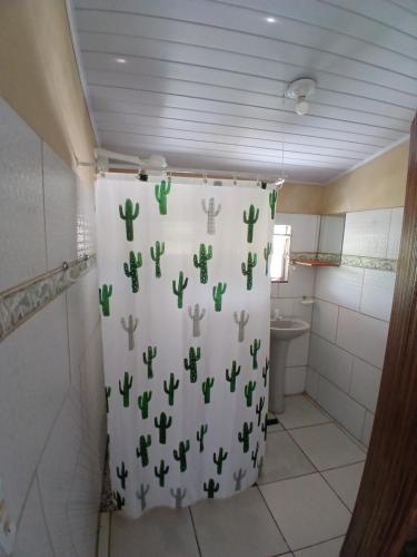 a bathroom with a shower curtain with cactus on it at Pousada Unidos in Jijoca de Jericoacoara