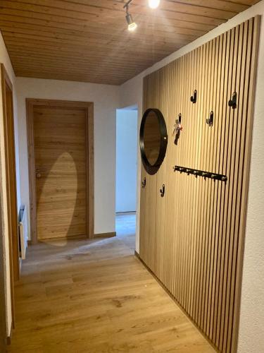 a hallway with a wooden wall with a mirror and shoes at Chasa ARLU in Samnaun - Laret