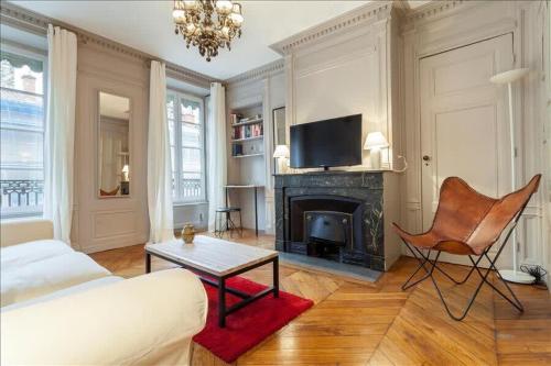 un salon avec un canapé et une cheminée dans l'établissement Colombe - Furnished apartment - Downtown Lyon, à Lyon