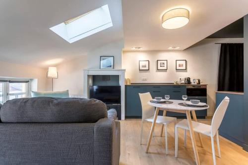 un salon avec un canapé et une table avec des chaises dans l'établissement Garet - Furnished apartment - Downtown Lyon, à Lyon