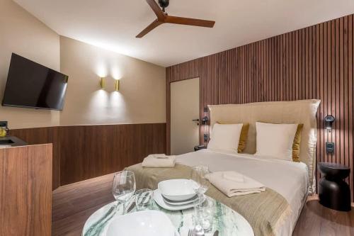 - une chambre avec un lit et une table avec des verres à vin dans l'établissement Zola - Furnished apartment - Downtown Lyon, à Lyon