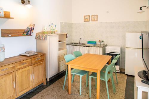 a kitchen with a table and chairs and a refrigerator at Agriturismo La Genziana in Alghero