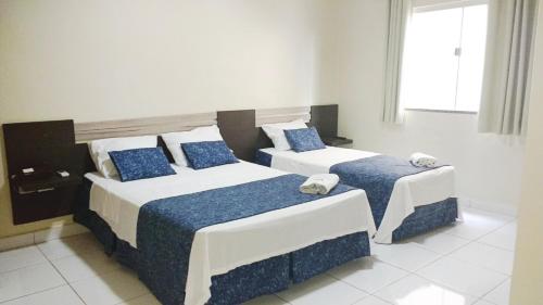 a bedroom with two beds with blue pillows at Palace Hotel in Altamira