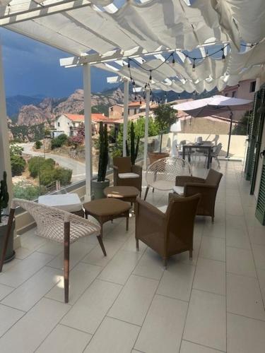 a patio with tables and chairs under an umbrella at Casa Mimosa in Piana