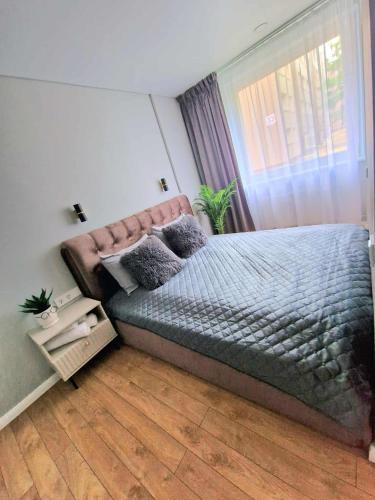a bedroom with a bed and a window at Namų mūza "A" SELF CHECK IN in Plungė