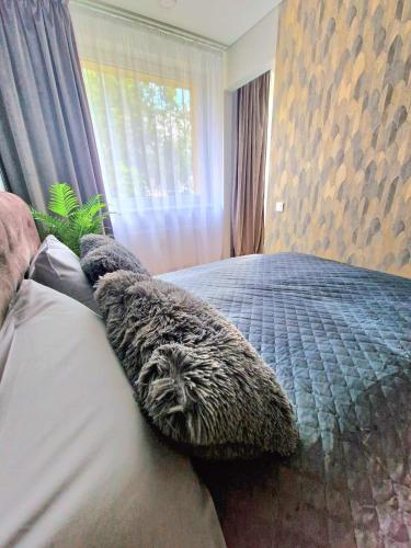a bedroom with a bed with pillows on it at Namų mūza "A" SELF CHECK IN in Plungė