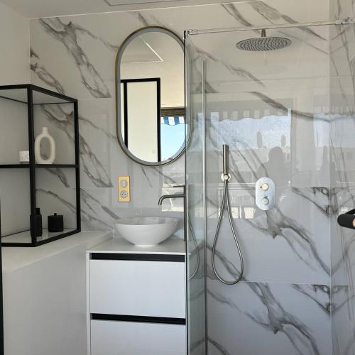 une salle de bain avec un lavabo et un miroir dans l'établissement Studio Luxe vue mer Persuasion - Héliopolis D 8 - 2 personnes, au Cap d'Agde