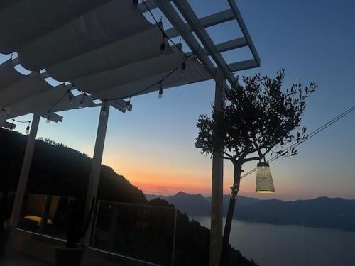 a building with a tree and a view of the water at Casa Mimosa in Piana
