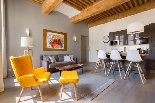 un salon avec une chaise jaune et un canapé dans l'établissement Pearl - Furnished apartment - Downtown Lyon, à Lyon