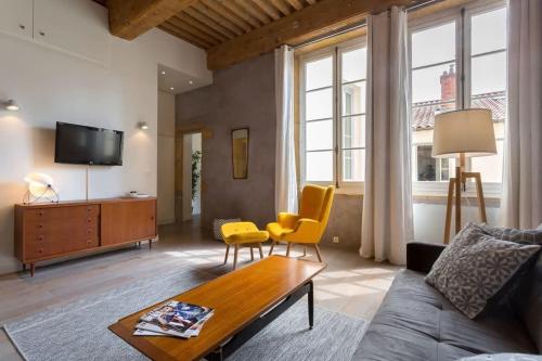 een woonkamer met een bank en een tafel bij Pearl - Furnished apartment - Downtown Lyon in Lyon