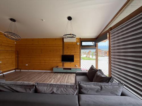 a living room with a couch and a flat screen tv at Cozy house 7 min walk from beach in Cholpon-Ata