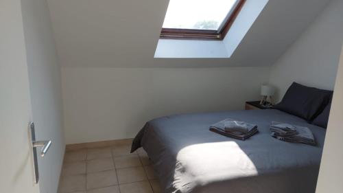 a small bedroom with a bed with a window at Welcome Home in Vert-le-Grand