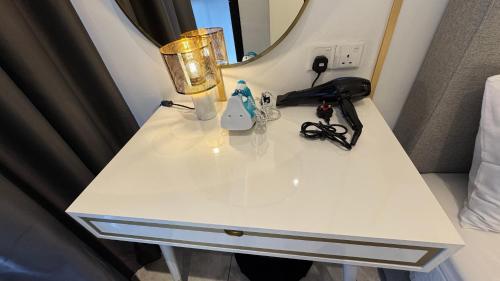 a white table with a lamp and a mirror at Axon Residence Near Fehrenheit Bukit Bintang in Kuala Lumpur