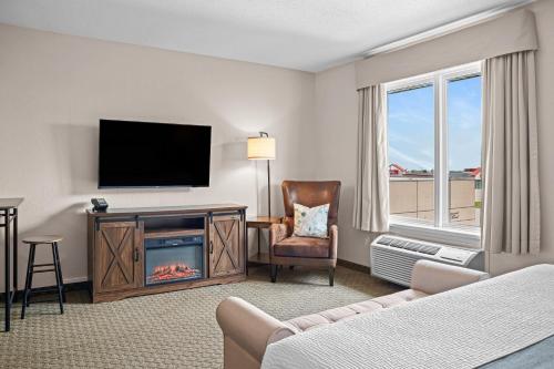 a living room with a fireplace and a television at Days Inn & Suites by Wyndham Winkler in Winkler