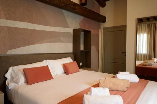 a bedroom with a large bed with two chairs at Borgo Bucciano in San Miniato
