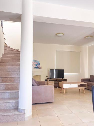 a living room with a couch and a tv at Villa Merope Irena 1 in Polis Chrysochous