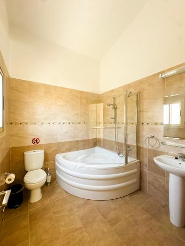 a bathroom with a tub and a toilet and a sink at Villa Merope Irena 1 in Polis Chrysochous