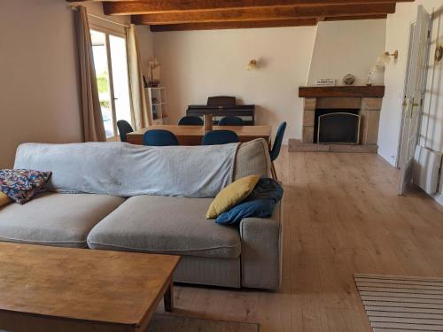 una sala de estar con un sofá y una mesa en l'Echappee belle Seaside break for 8 people, en Plougasnou