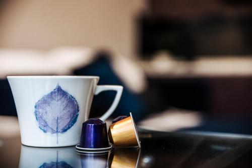 a cup with a leaf on it sitting on a table at Annex at The Stables in the Heart of England in Hinckley