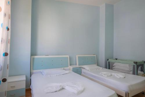two beds in a room with blue walls at Paris Luxury Penthouse in Sarandë