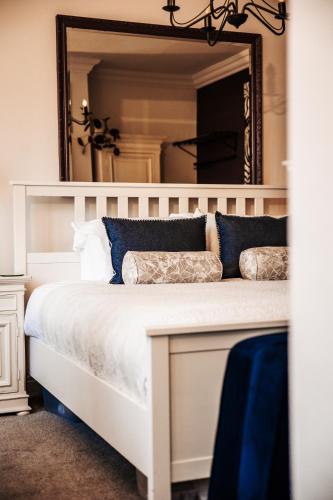 a bedroom with a white bed with a large mirror at Annex at The Stables in the Heart of England in Hinckley
