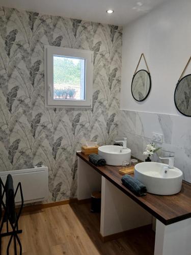 a bathroom with two sinks on a wooden counter at Les Oliviers in Chériennes