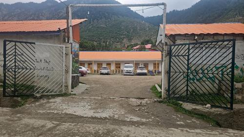 two gates in a parking lot in front of a building at Green World Hotel and restaurant in Tāl