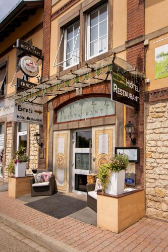 a store front of a hotel with plants in front of it at La Maison ERNENWEIN in Obermodern