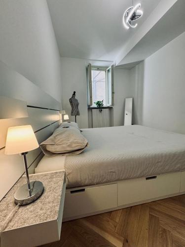a bedroom with a bed and a lamp on a table at WANDERLUST Splendido appartamento in centro in Pavia