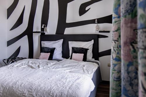 a bedroom with a bed with white sheets and pillows at La Maison ERNENWEIN in Obermodern