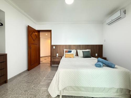 a bedroom with a large white bed with blue pillows at RG01- 3 Suítes| Pé na Areia| Vista Mar| Churrasq in Balneário Camboriú