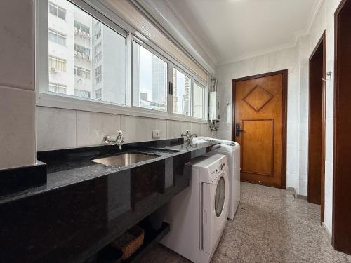 a bathroom with a sink and a washing machine at RG01- 3 Suítes| Pé na Areia| Vista Mar| Churrasq in Balneário Camboriú