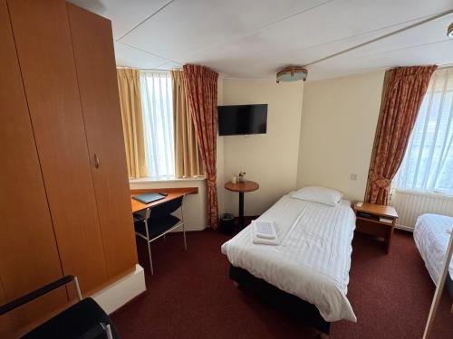 a hotel room with a bed and a desk at Hotel Kuik in Ruinen
