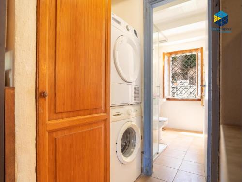 a bathroom with a washer and dryer in a room at The Old Fisherman House in Cala Figuera