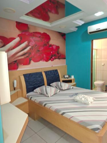 a bedroom with a bed with red flowers on the wall at papillon hotel in Sao Paulo