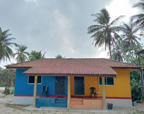 a small colorful house with two chairs in it at Chalet Barokah Seaview in Bachok