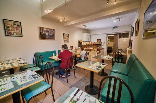two people sitting at tables in a restaurant at La Caravelle in Riom